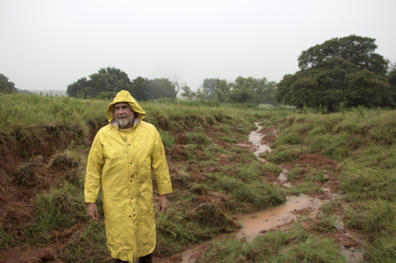 Oklahoma Conservation Commission Watershed Technitian Dennis Boney inspects damage to Wildhorse 80's spillway in Garvin County. 